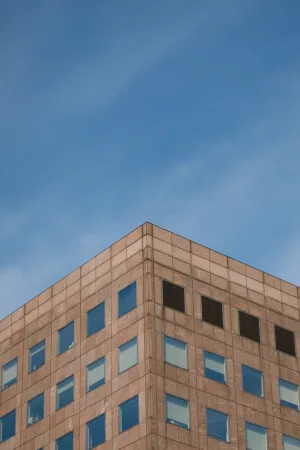 The corner of a London office building against a blue sky.
