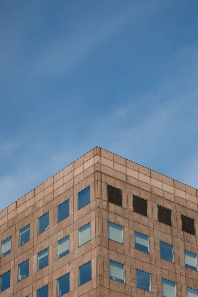 The corner of a London office building against a blue sky.