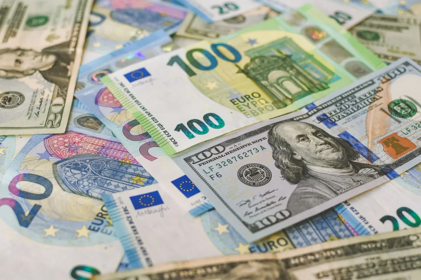 US dollar and euro banknotes arranged together to illustrate currency exchange.