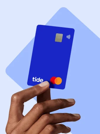 A hand holding a blue Tide business debit card.